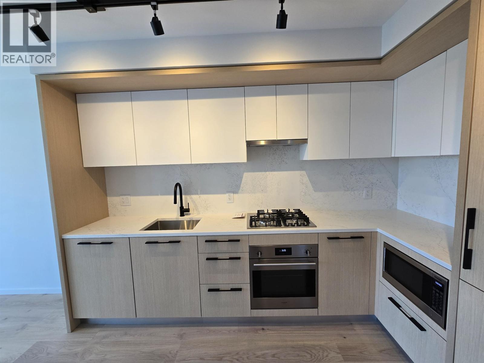 A modern kitchen with a stove top oven and a microwave.