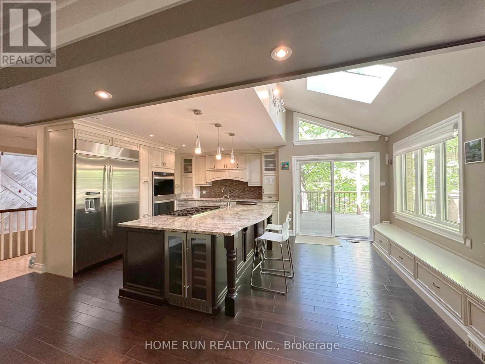A spacious kitchen with a skylight and a dining area with a table set for four.