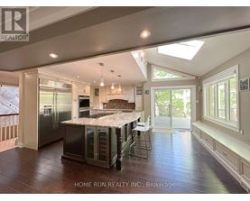 A spacious kitchen with a skylight and a dining area with a table set for four.