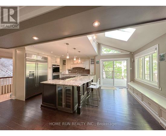 A spacious kitchen with a skylight and a dining area with a table set for four.