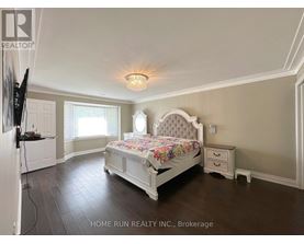 A bedroom with a large bed and a television on the wall.