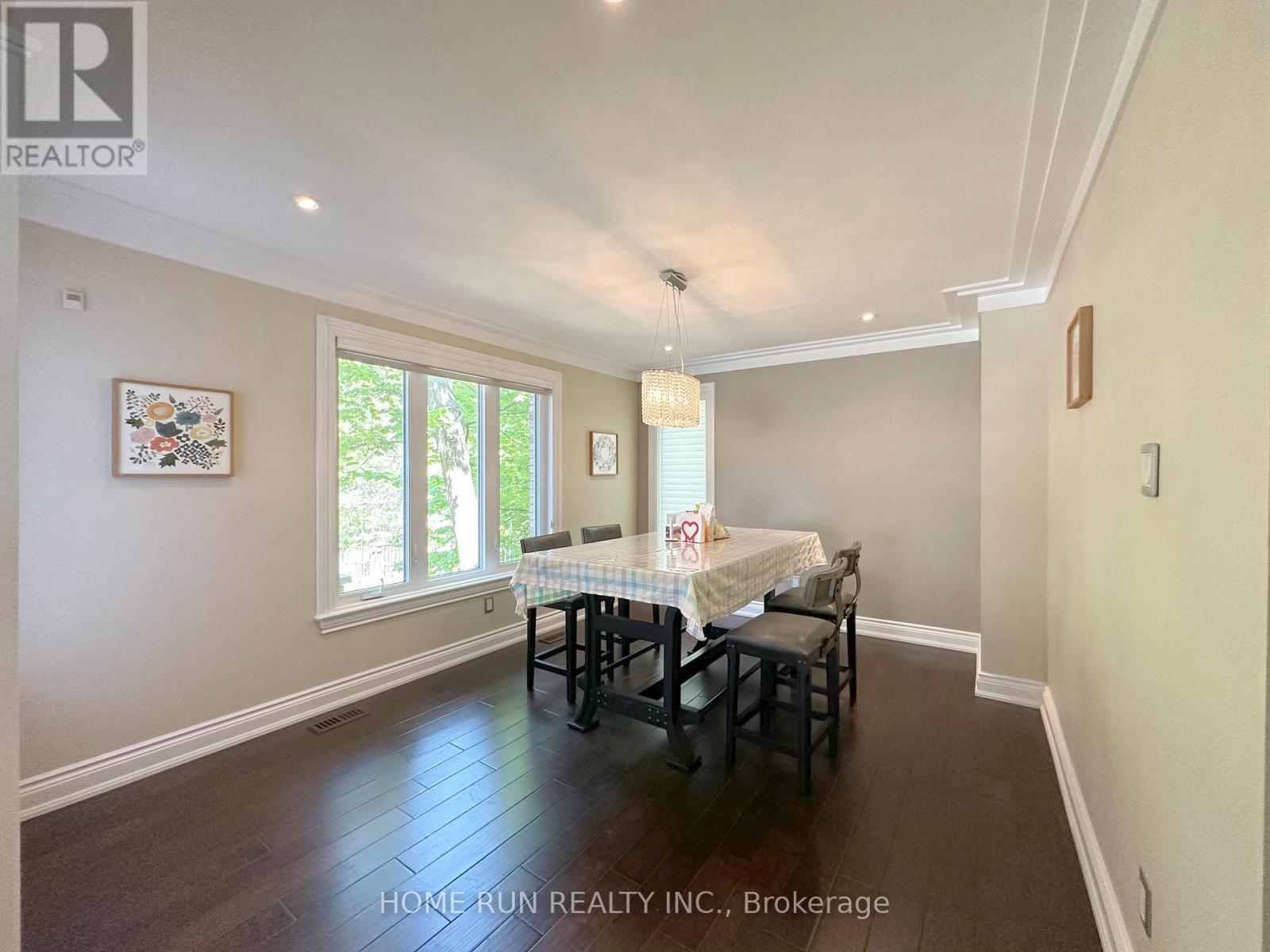 A dining room with a table set for two and a window letting in light.