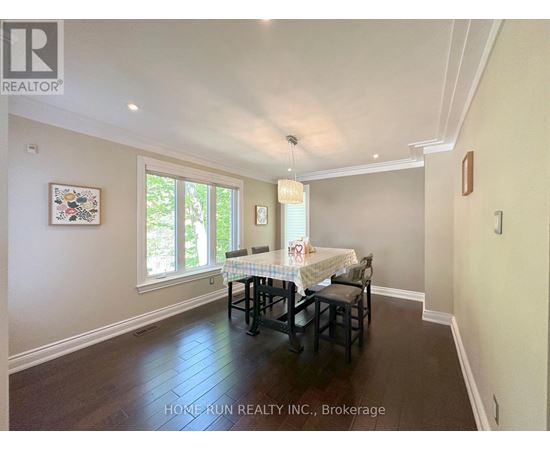 A dining room with a table set for two and a window letting in light.