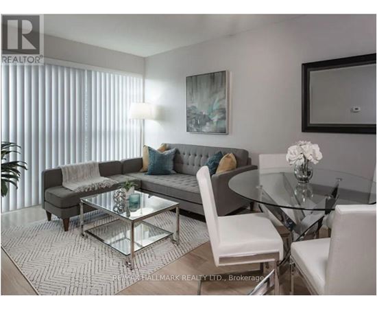 A modern living room with a glass table and white chairs.