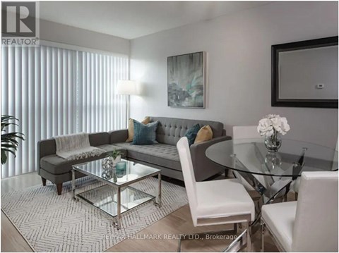 A modern living room with a glass table and white chairs.
