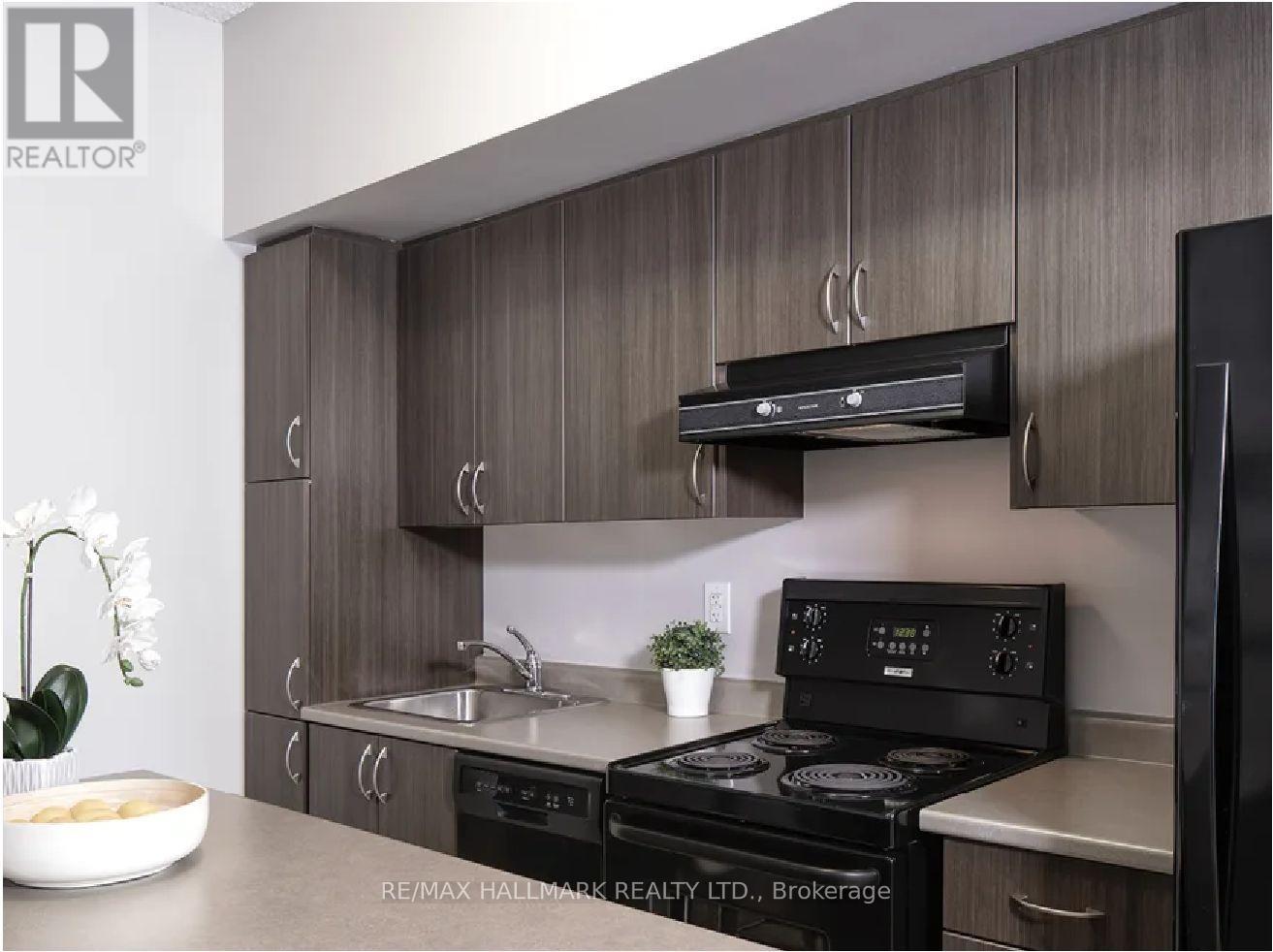 A modern kitchen with a brokerage sign on the wall.