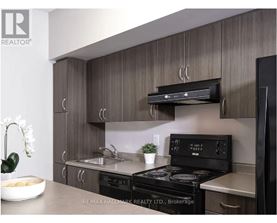 A modern kitchen with a brokerage sign on the wall.