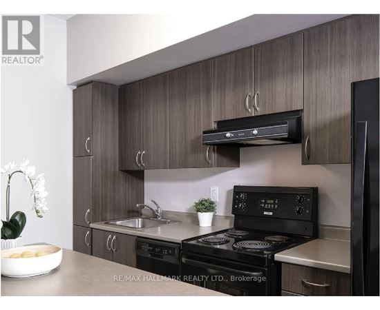 A modern kitchen with a brokerage sign on the wall.