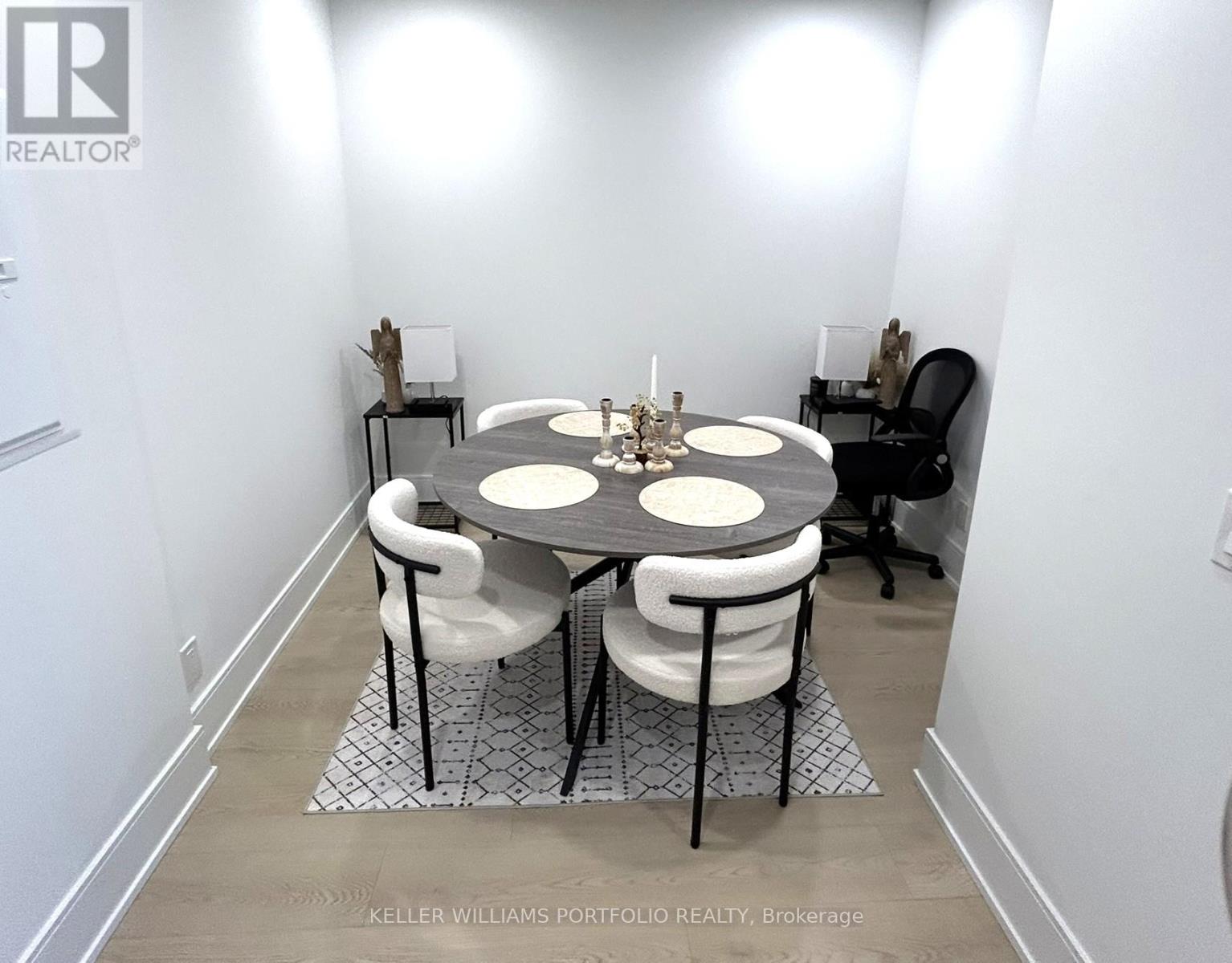 A dining room with a round table and chairs.
