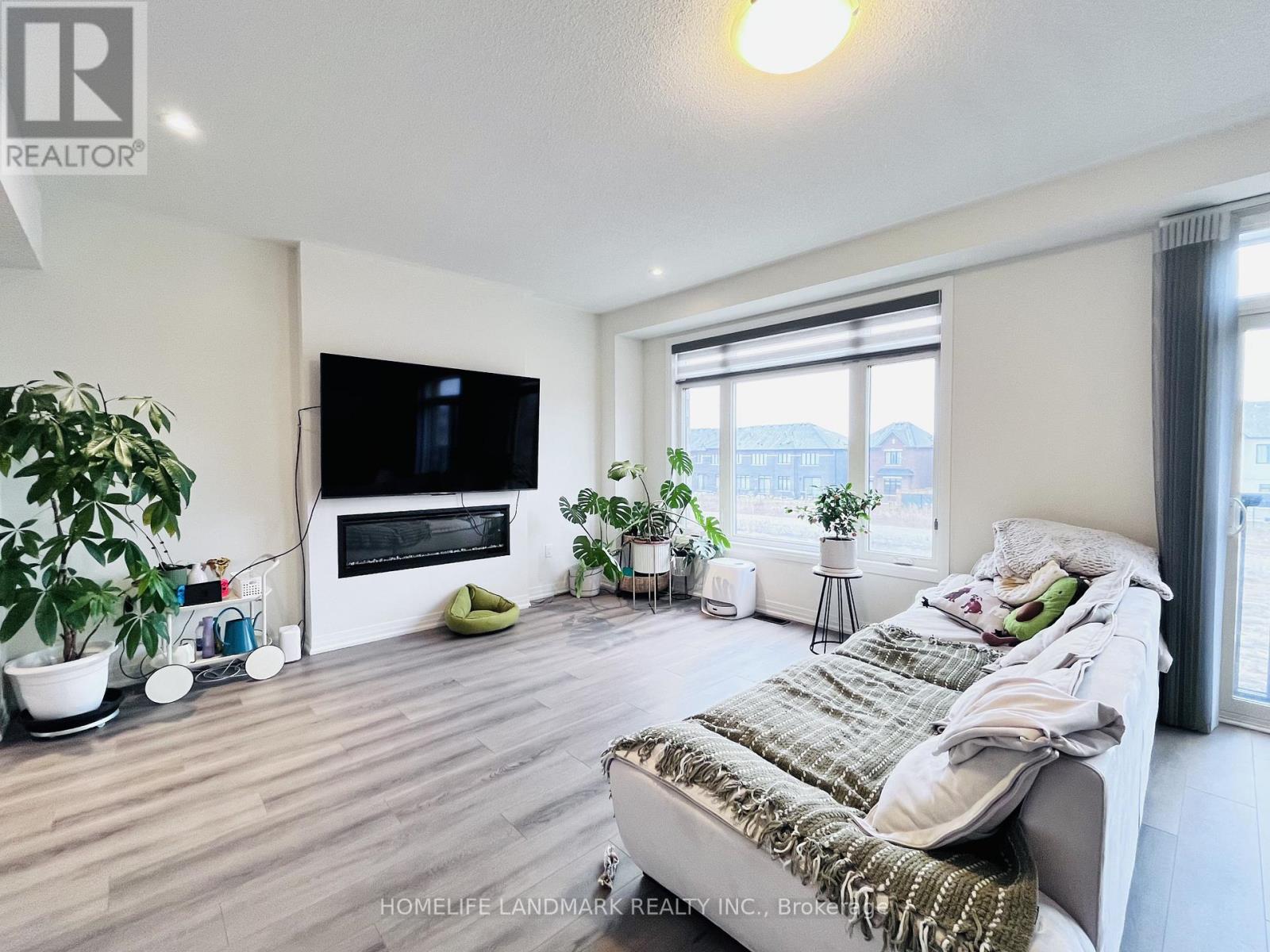 A living room with a couch, a television, and a fireplace.