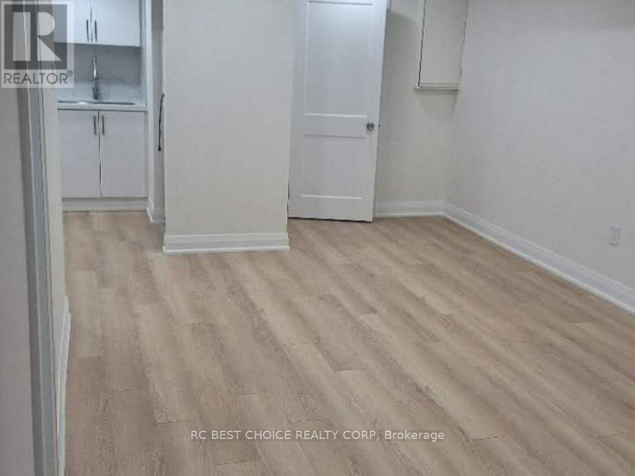A room with wood flooring and white walls.