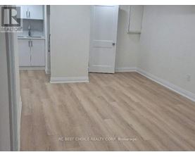 A room with wood flooring and white walls.