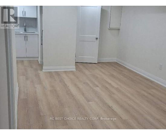 A room with wood flooring and white walls.