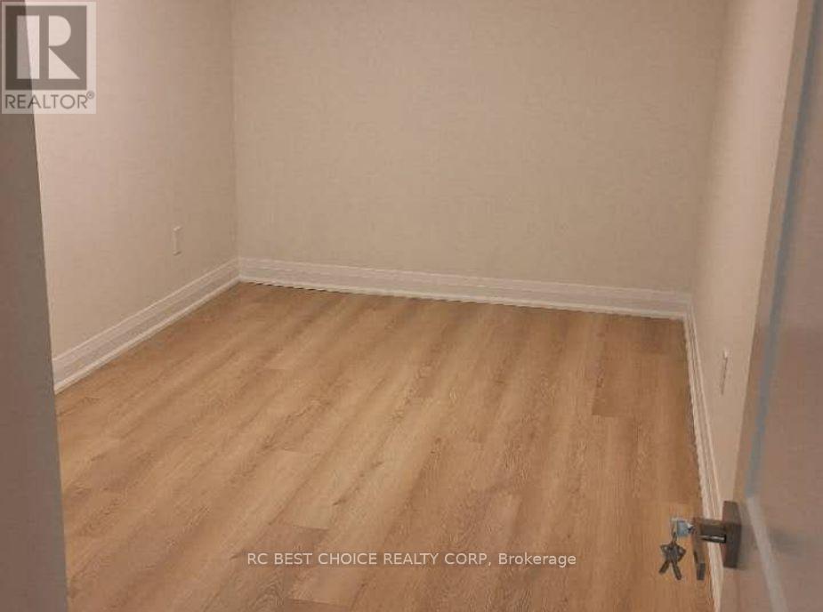 A room with wooden flooring and white walls.