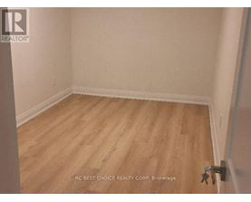 A room with wooden flooring and white walls.