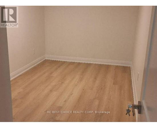A room with wooden flooring and white walls.