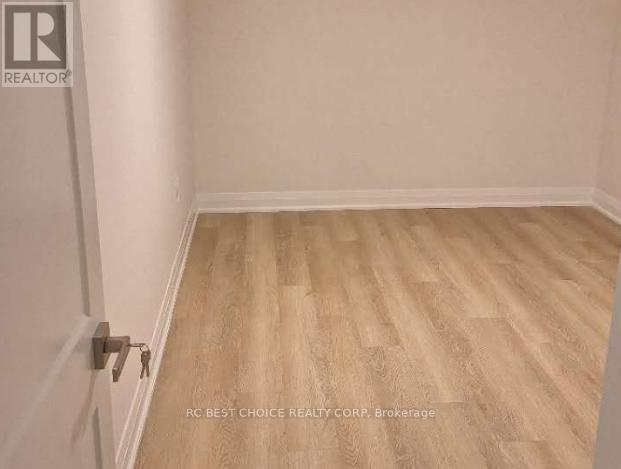 A room with wooden flooring and a door with a key in it.
