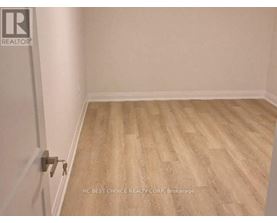 A room with wooden flooring and a door with a key in it.