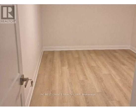 A room with wooden flooring and a door with a key in it.