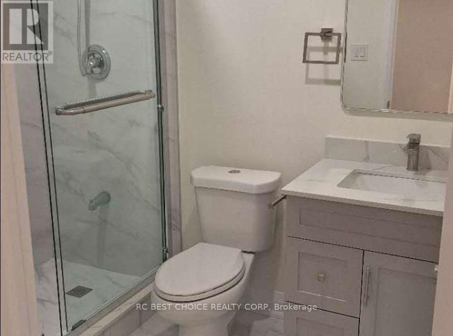 A white toilet sits next to a sink in a bathroom.