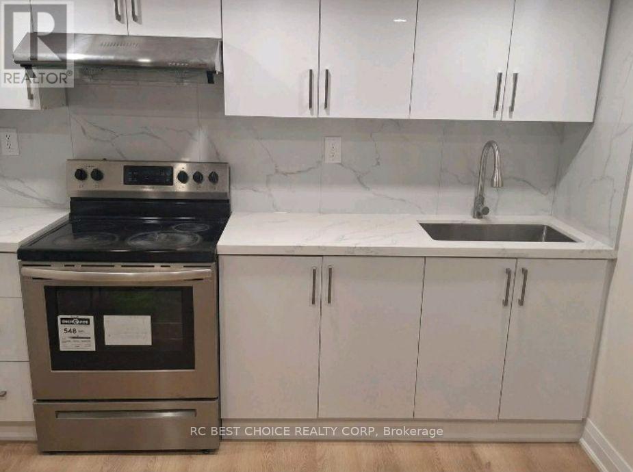 A kitchen with a stove and sink.