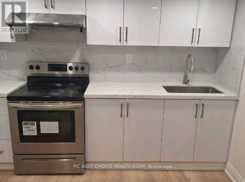 A kitchen with a stove and sink.
