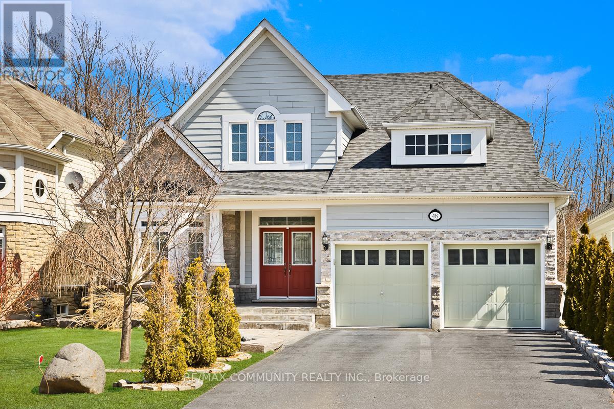 A large house with a red door and two garages.