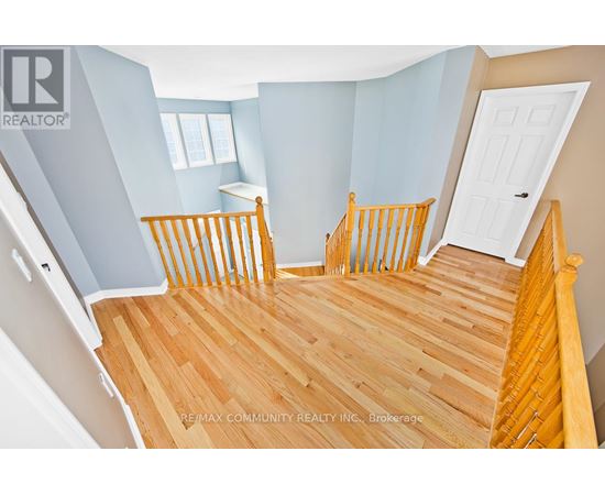A bedroom with a wooden floor and a white door.