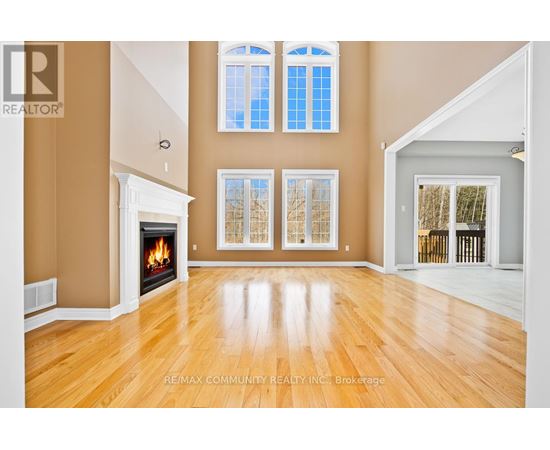 A spacious room with a fireplace and large windows.
