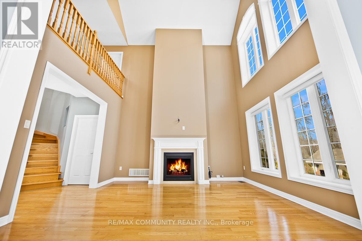 A spacious living room with a fireplace and a staircase.