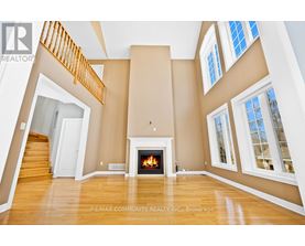 A spacious living room with a fireplace and a staircase.