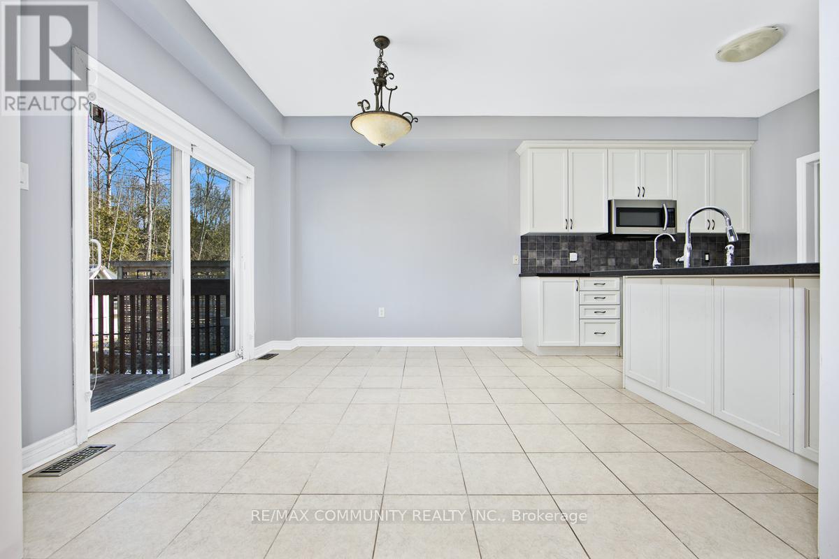 A spacious kitchen with white cabinets and a black countertop.