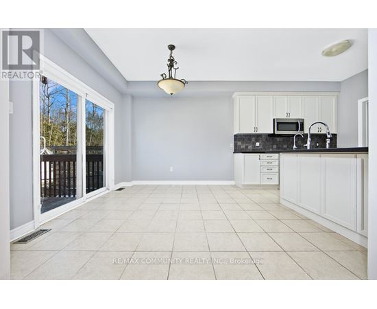 A spacious kitchen with white cabinets and a black countertop.