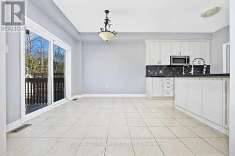 A spacious kitchen with white cabinets and a black countertop.