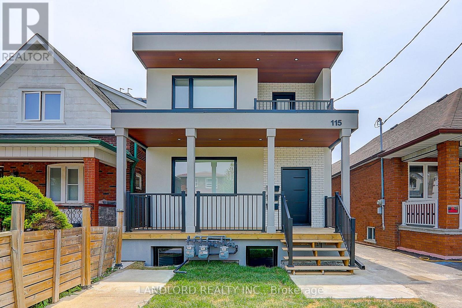 A two-story house with a balcony and a black door is for sale.
