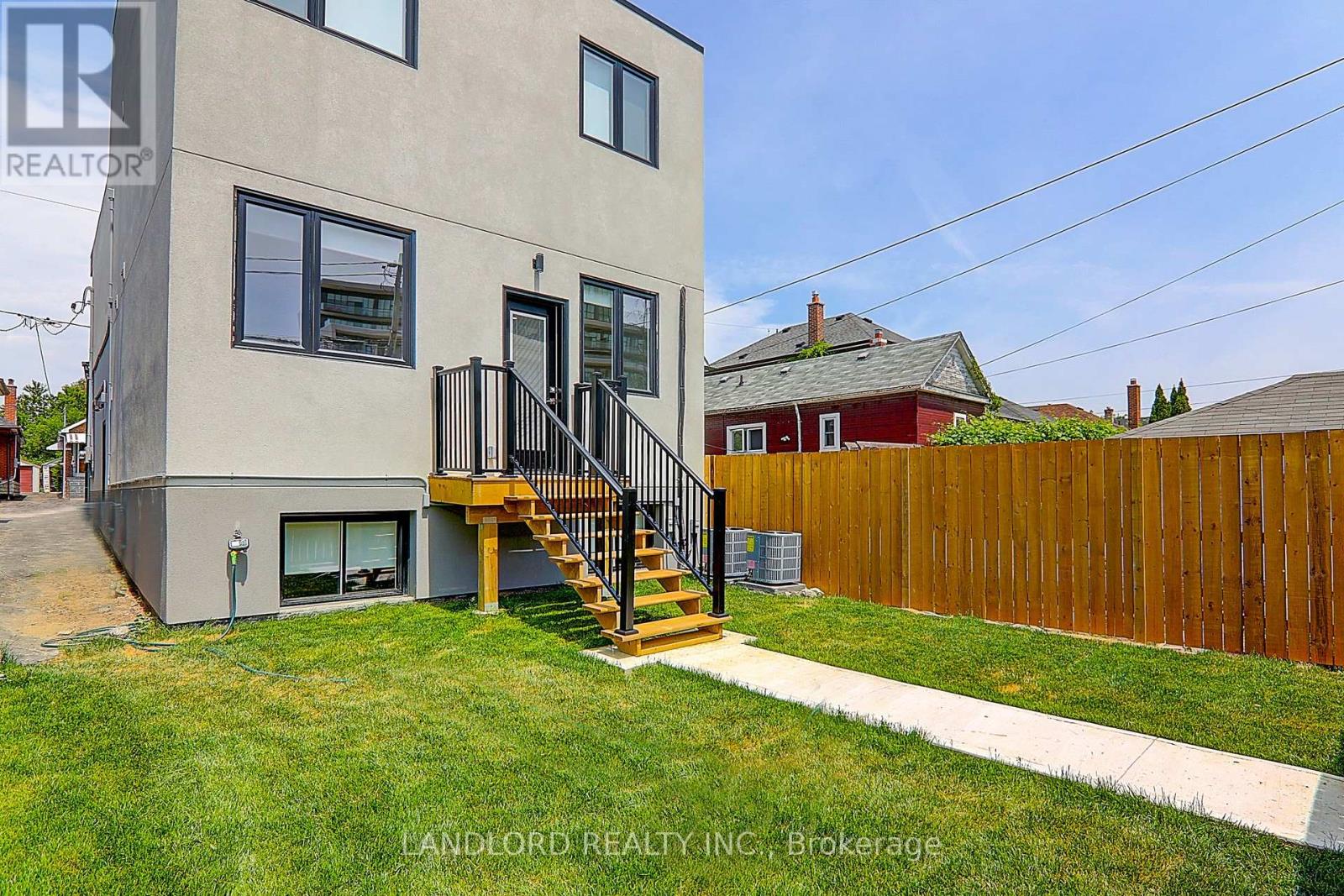 A modern house with a grey exterior and a wooden fence.