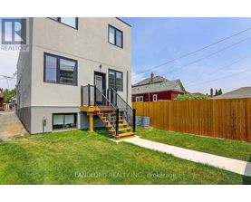 A modern house with a grey exterior and a wooden fence.