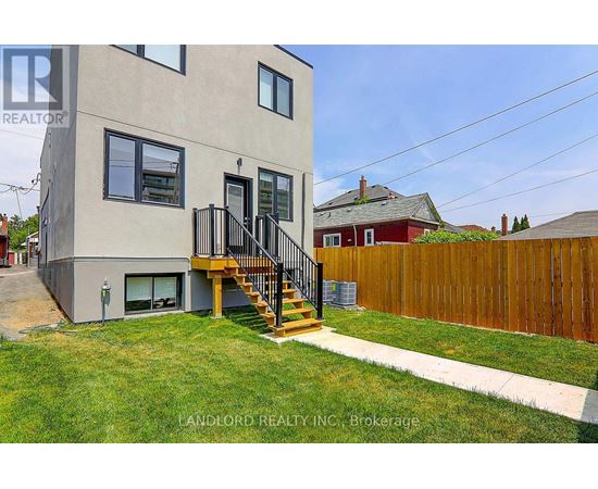 A modern house with a grey exterior and a wooden fence.