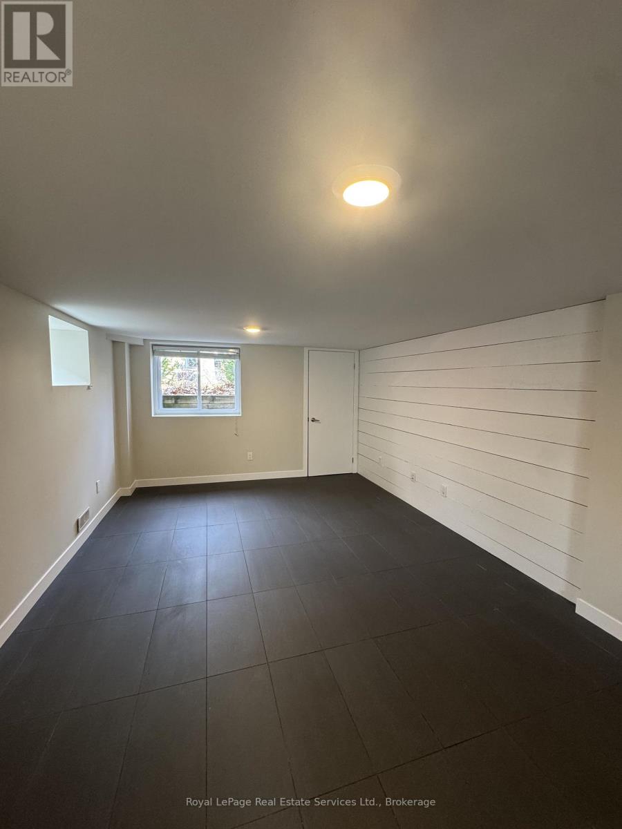 A room with white walls and a window with a view of trees.