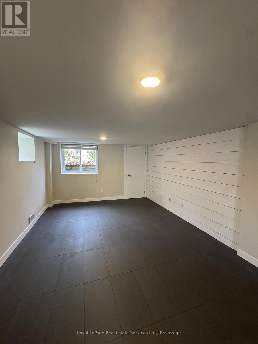 A room with white walls and a window with a view of trees.