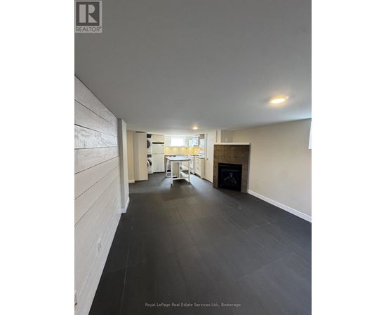 A spacious room with a fireplace and a dining table.