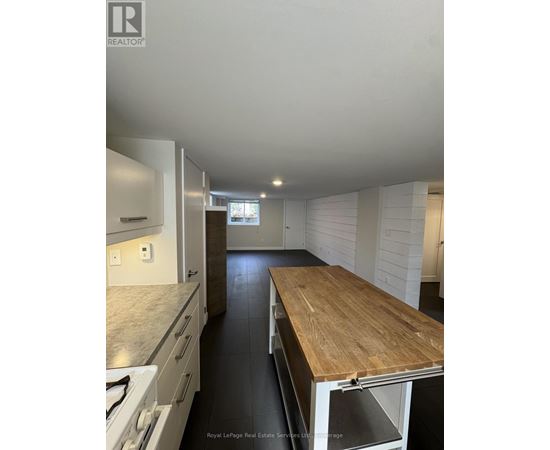 A kitchen with a wooden counter top and white cabinets.
