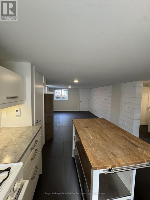 A kitchen with a wooden counter top and white cabinets.