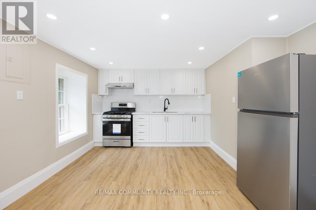 A kitchen with white cabinets and a stainless steel refrigerator.