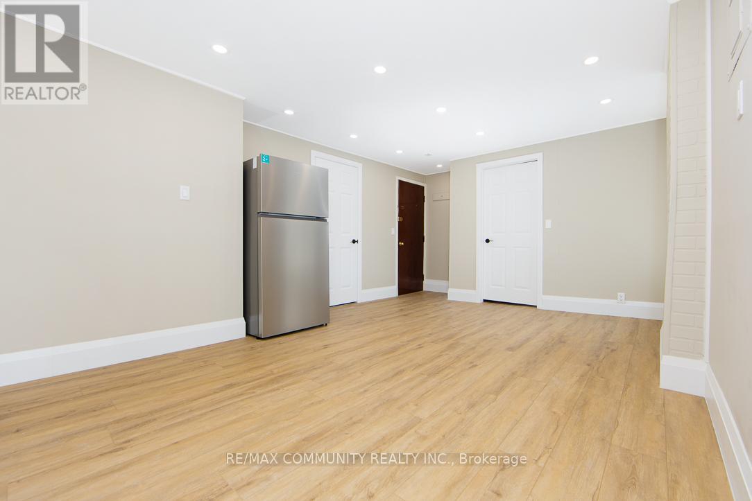 A spacious room with a refrigerator in the corner.