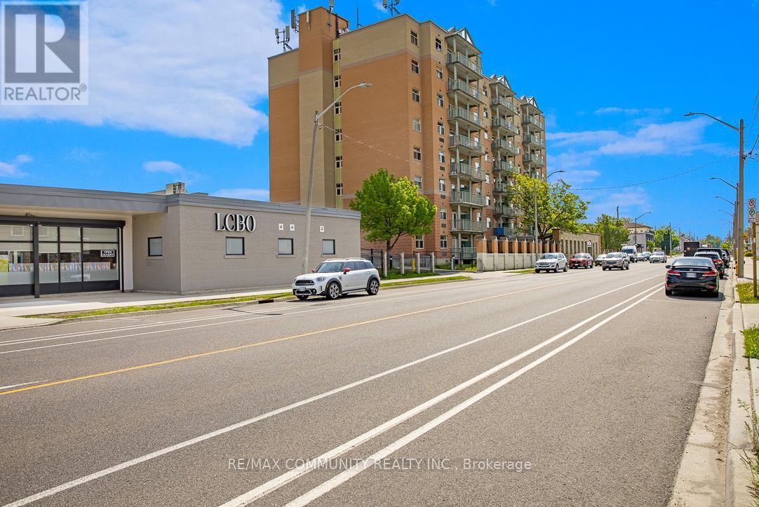 A street view with a car driving on the road and buildings on the side.