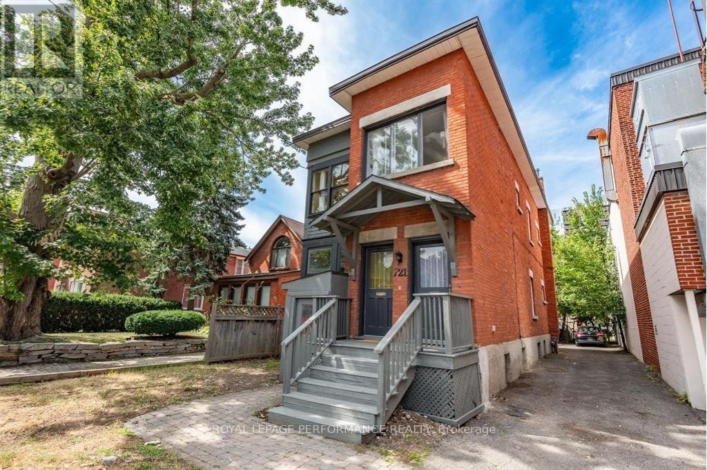 A red brick house with a grey front porch and stairs.