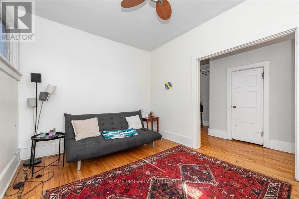 A living room with a grey couch and a red rug.