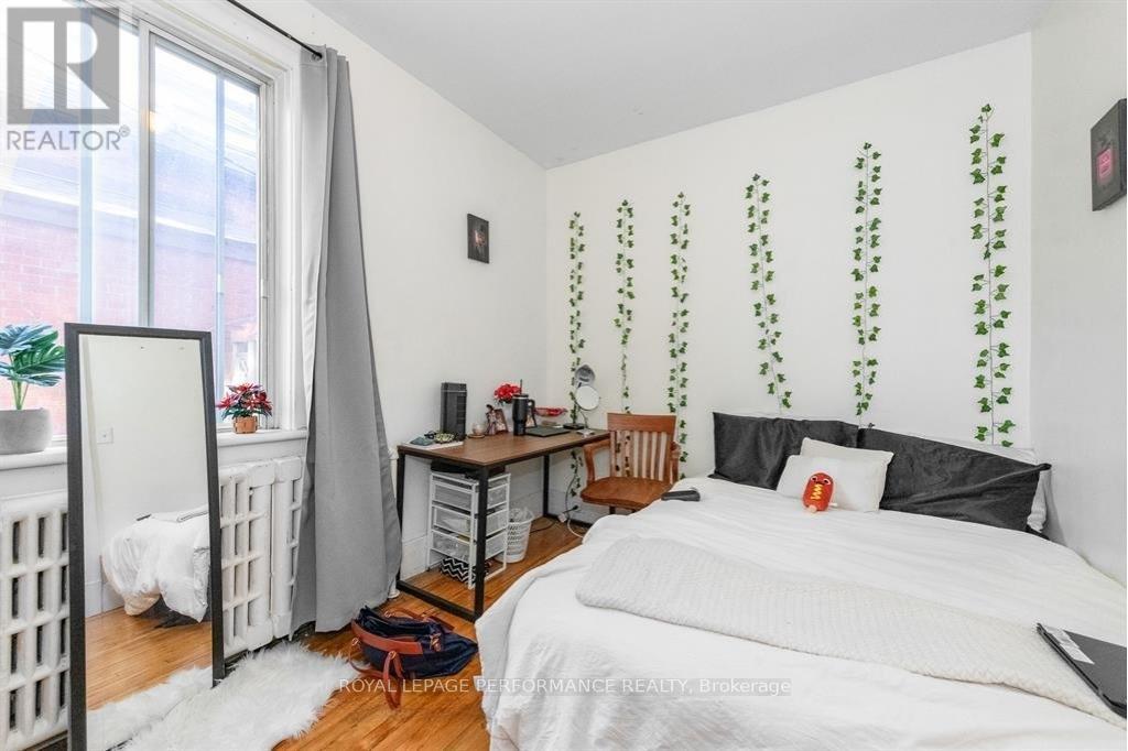A bedroom with a white bed and a desk with a computer.