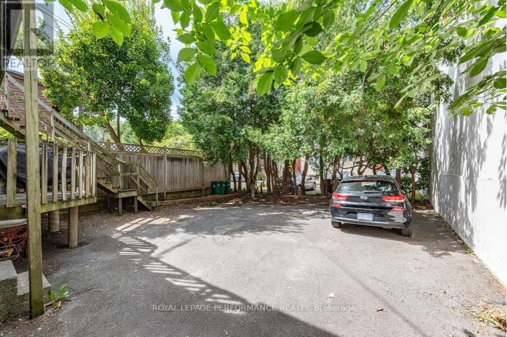 A car is parked in a driveway surrounded by trees.